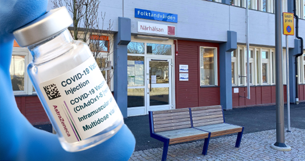 Bilden är ett montage av en flaska covid-19 vaccin framför entrén till en vårdcentral.