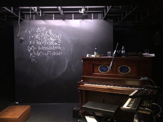 Den lilla scenen. Rekvisitan står framme på scenen, ett piano och tavlan med ekvationer. 