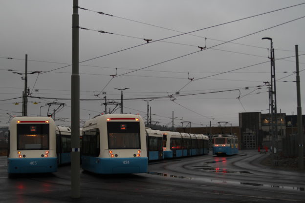 Tre spårvagnar uppställda i regnet framför den nya spårvagnsdepån på Ringön